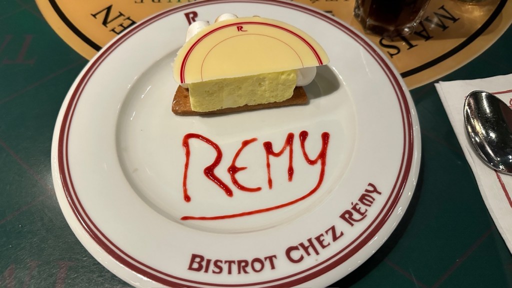 A Lemon Meringue tart on a plat with 'Remy' written on it in red gel