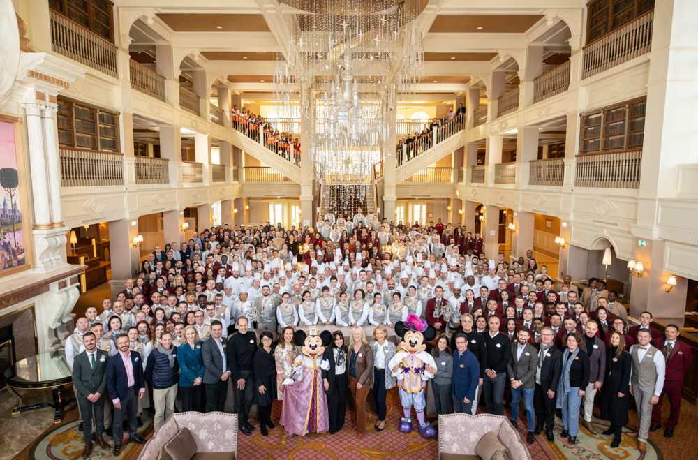People with Mickey and Minnie Mouse in the lobby of Disneyland Hotel at Disneyland Paris