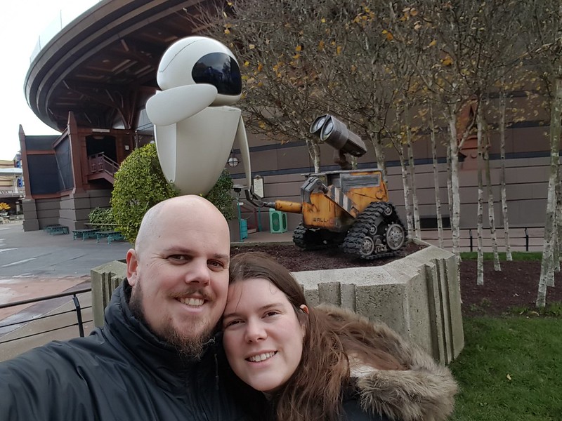 Man and woman in front of statue of Wall-e and Eve at Disneyland Paris