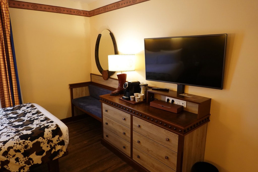Bed, TV and dresser in a room at Disney's Hotel Cheyenne at Disneyland Paris