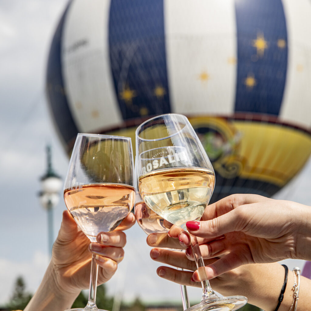 Wine glasses being clinked together outside the balloon in Disney Village in Disneyland Paris