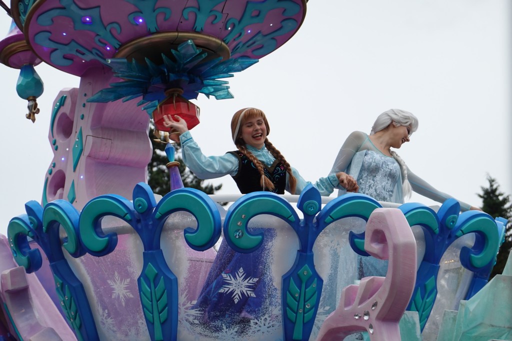 Anna and Elsa from Frozen on a parade float at Disney