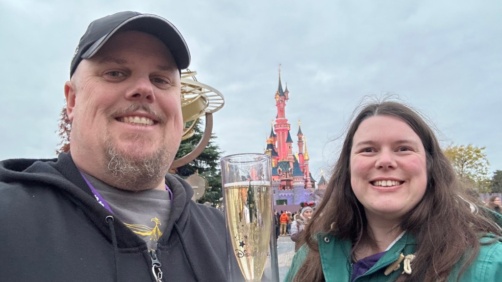 Man and woman with champagne outside Sleeping Beauty Castle in Disneyland Paris