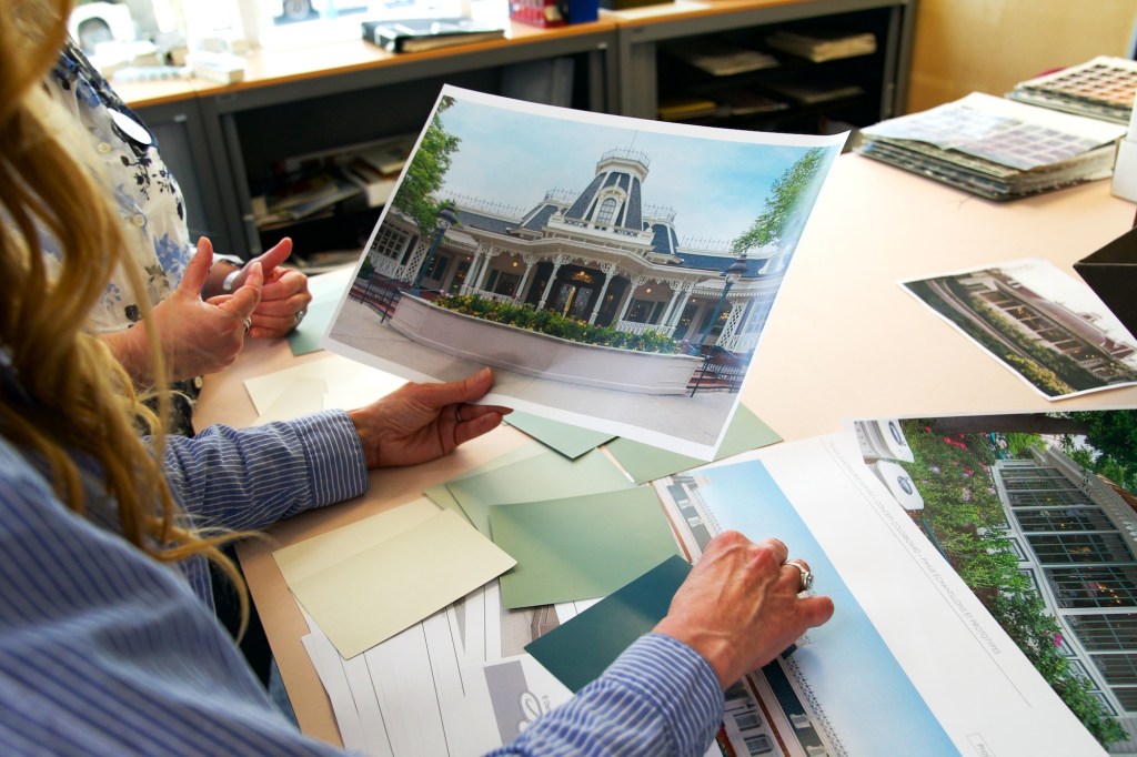 Imagineers looking at concept art for the Plaza Gardens restaurant in Disneyland Paris